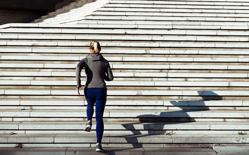 Donna che fa jogging su per una scalinata