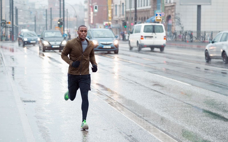 Uomo fa jogging sotto la pioggia in città