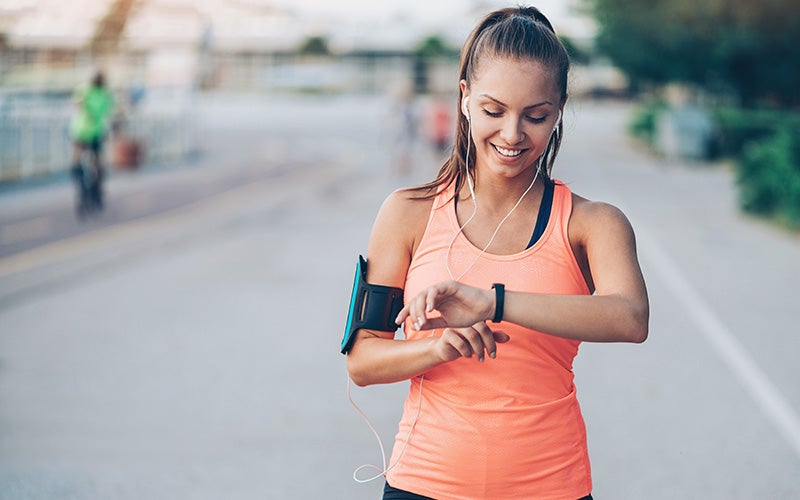 Donna controlla la sua frequenza cardiaca con un orologio fitness dopo aver fatto jogging