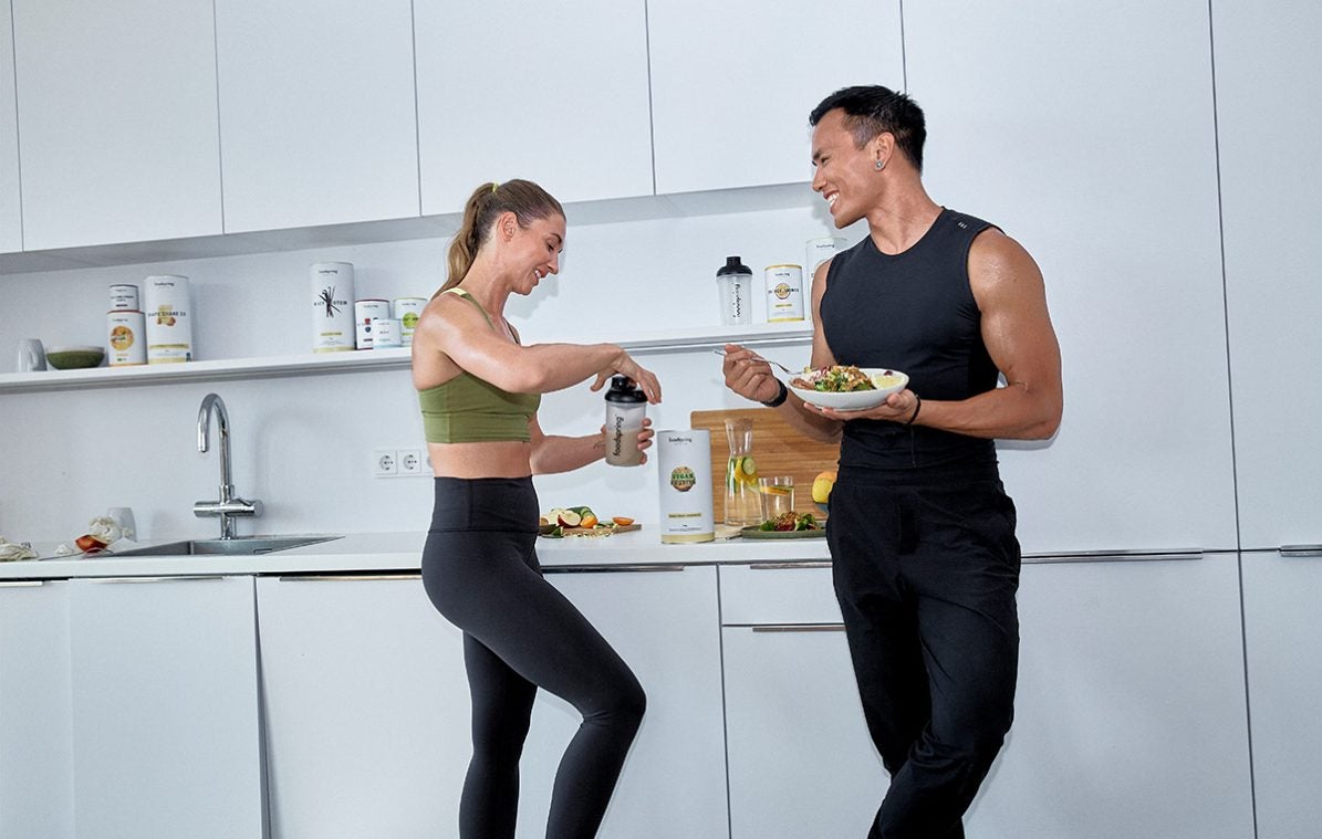 Mann und Frau stehen in der Küche und essen