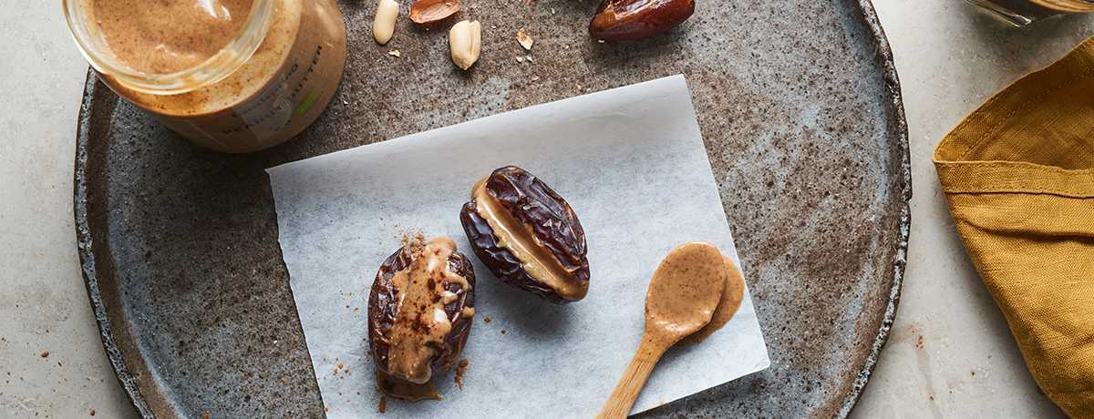 dates filled with peanut butter on a gray and brown speckled plate