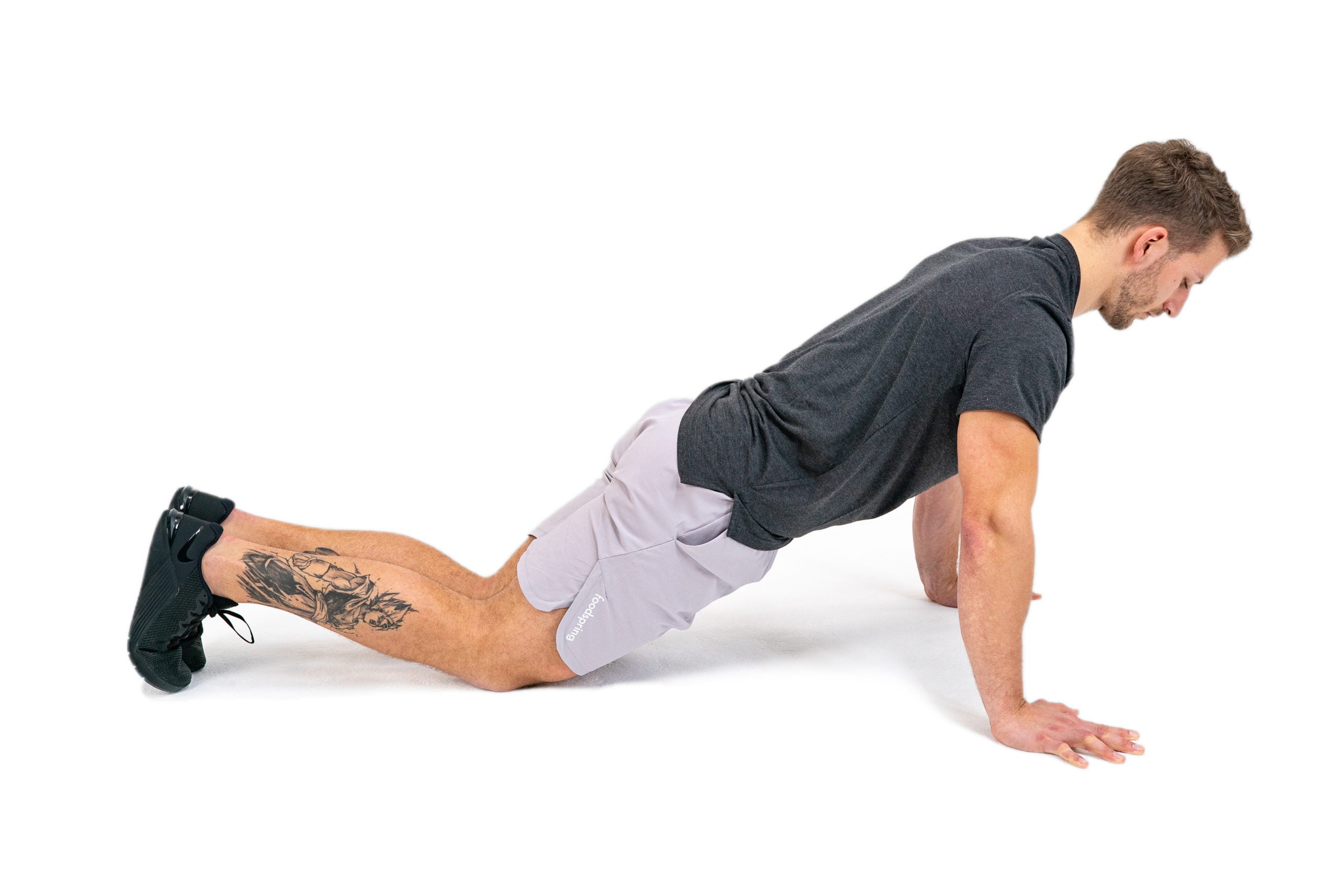 White man in workout gear performs a knee push-up
