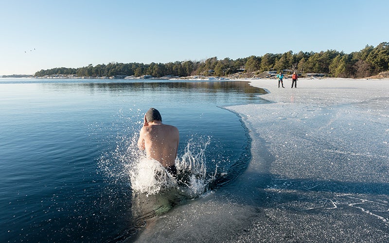 Uomo si tuffa in un lago semi ghiacciato