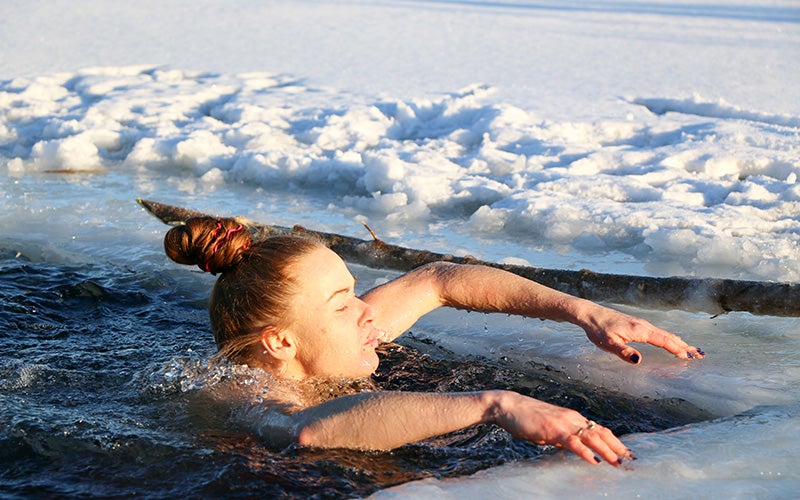 Donna che fa il bagno nell'acqua ghiacciata di un lago
