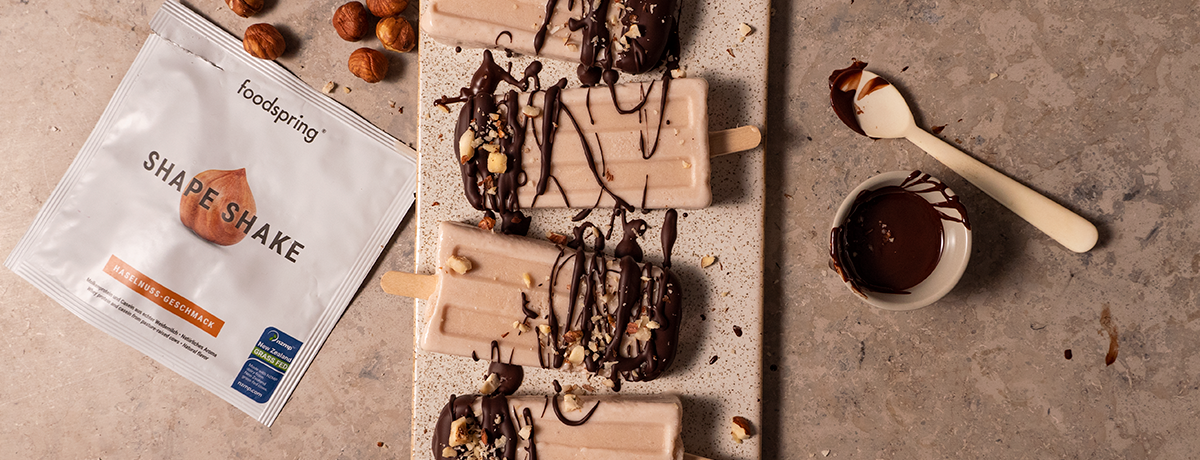 a trio of hazelnut protein popsicles drizzled with dark chocolate and topped with chopped hazelnuts
