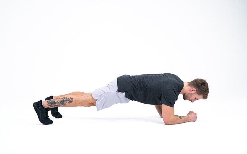 A white man performs a plank to improve his mind-muscle connection