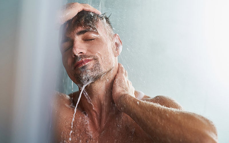 Mann duscht sich warm nach dem Training