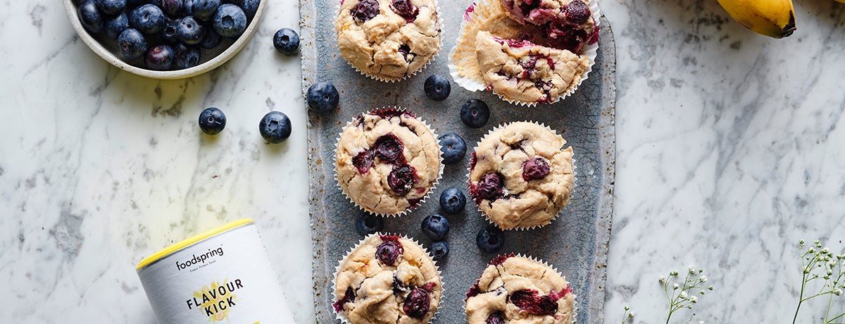 A tray of blueberry muffins with fresh blueberries interspersed between the muffins, for flourless recipes with the healthiest twist