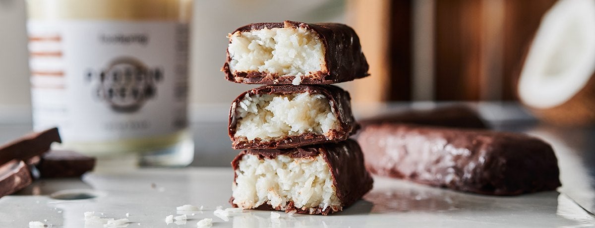 A stack of pieces of coconut-chocolate almond bars made with foodspring Protein Cream