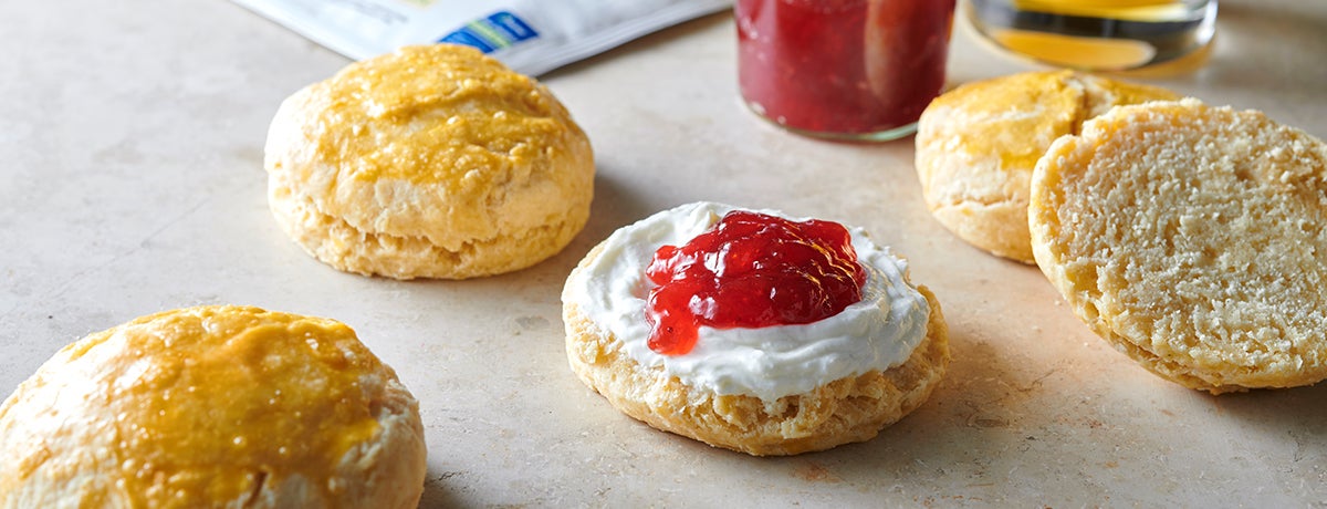 A closely cropped image of protein scones topped with cream and strawberry jam