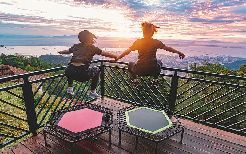 Due donne saltano sul trampolino su una terrazza