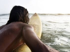Mann paddelt auf Surfboard
