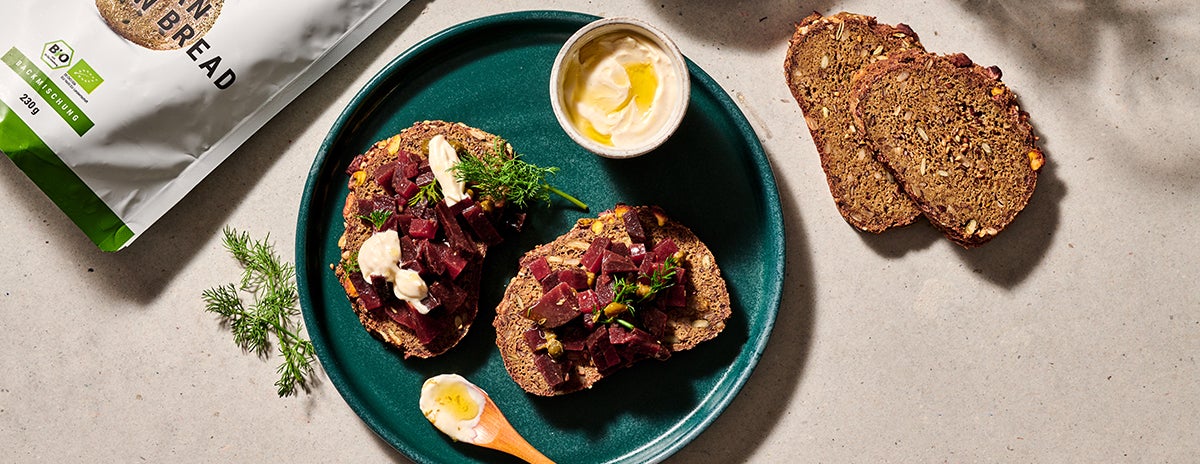 beetroot tartare on slices of Protein Bread on a teal plate as seen from above