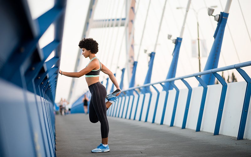 Runner donna fa stretching su un ponte