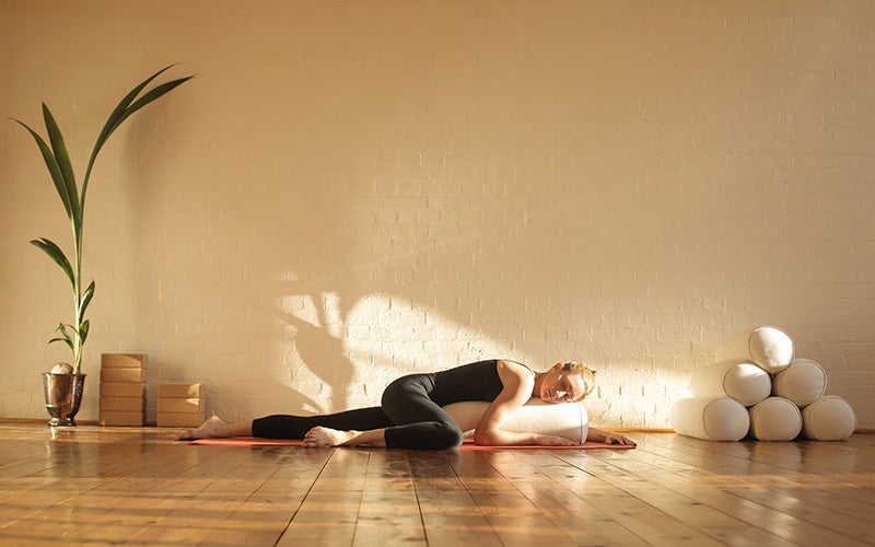 Eine Frau macht Restorative Yoga