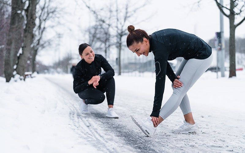 Zwei Frauen machen draußen Sport im Winter