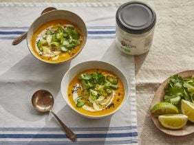 bowls of roasted carrot ginger soup with coriander and lime