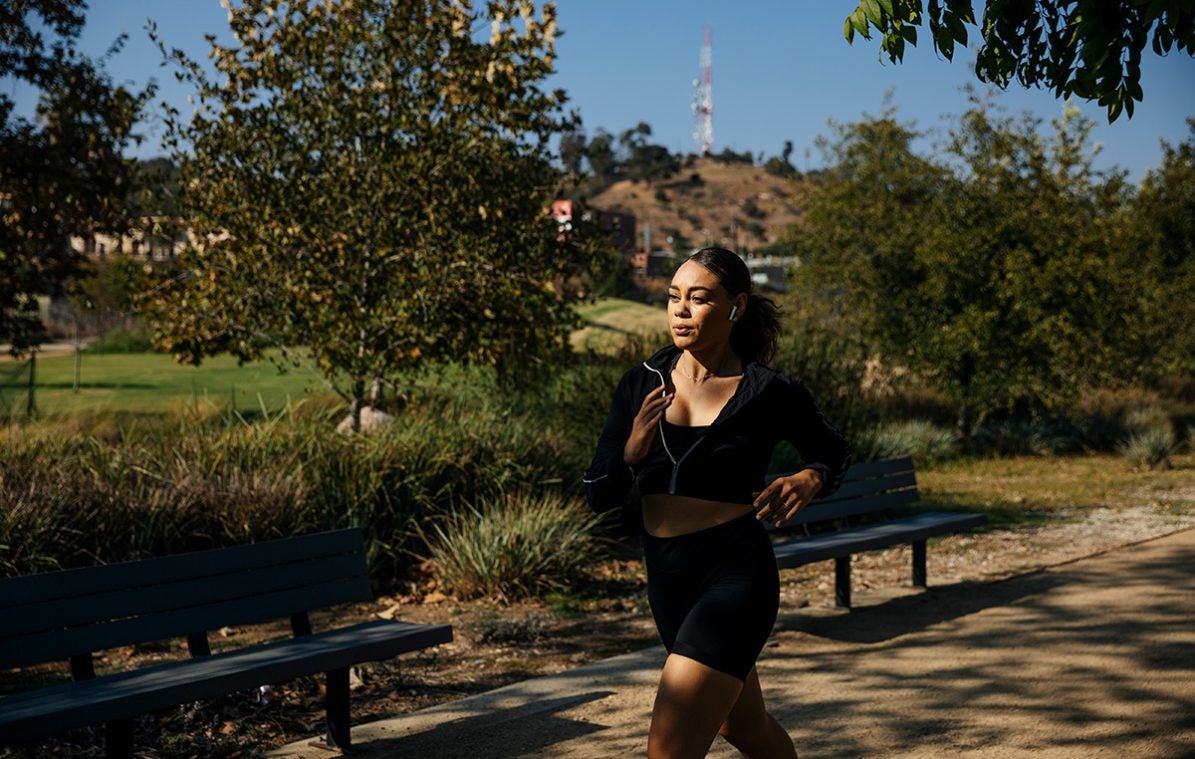 Eine Frau joggt draußen im Park