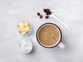 Bulletproof Coffee Zutaten neben einer Tasse Kaffee