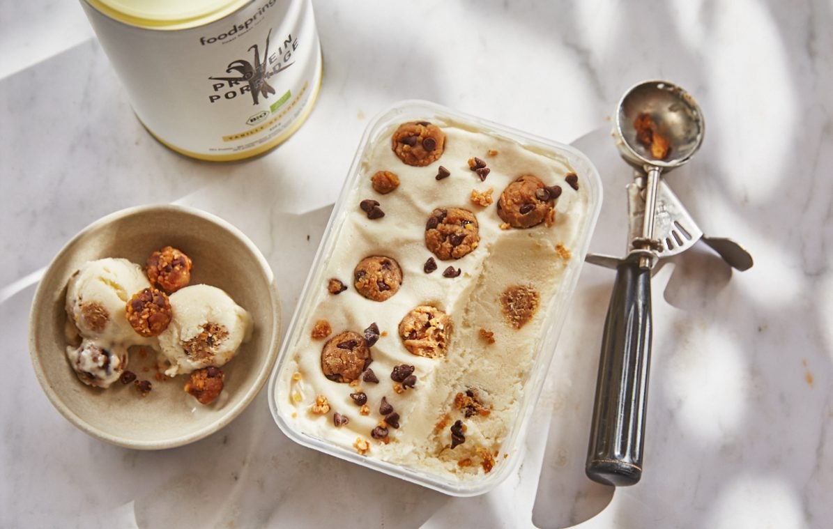 vanilla cookie dough ice cream in a tub with scoops taken