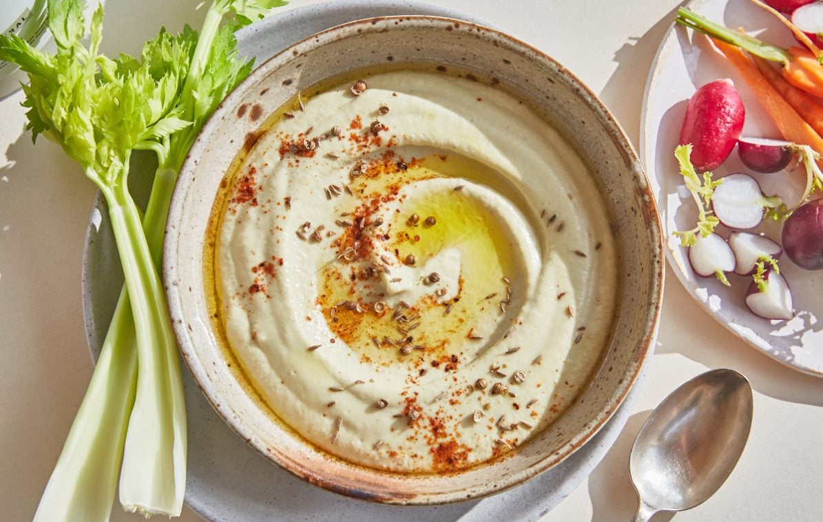 low carb courgette hummus in a bowl drizzled with oil served with crudités