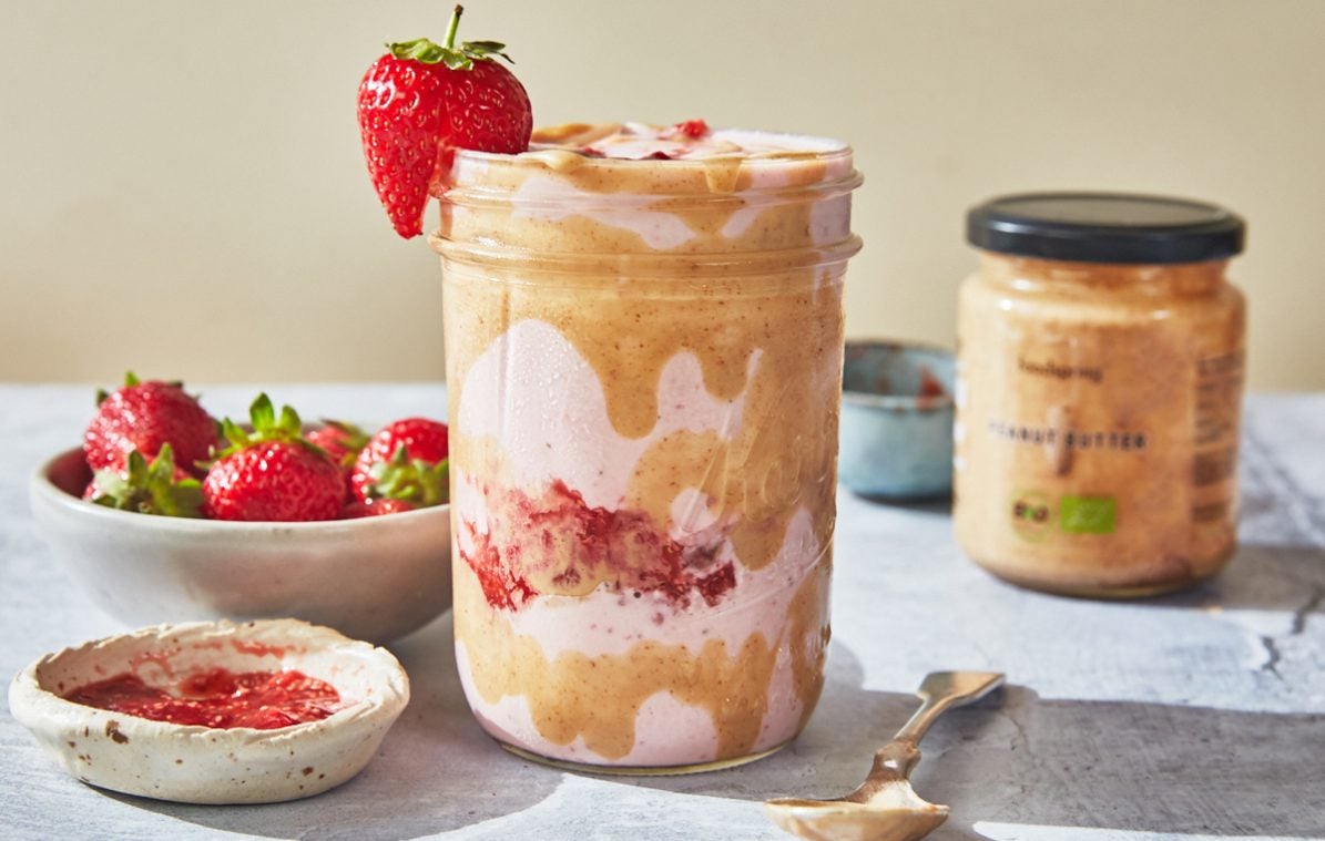 peanut butter strawberry smoothie in a mason jar swirled with peanut butter
