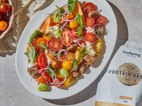 high protein healthy panzanella salad on a white oval plate