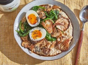 savoury oatmeal in a bowl topped with soft boiled egg, mushrooms and spinach