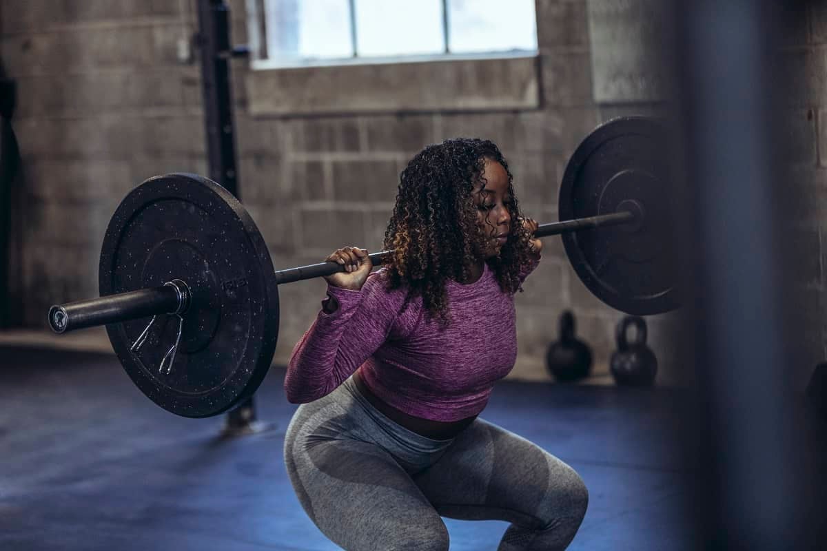 Woman lifting dumbbell on shoulder